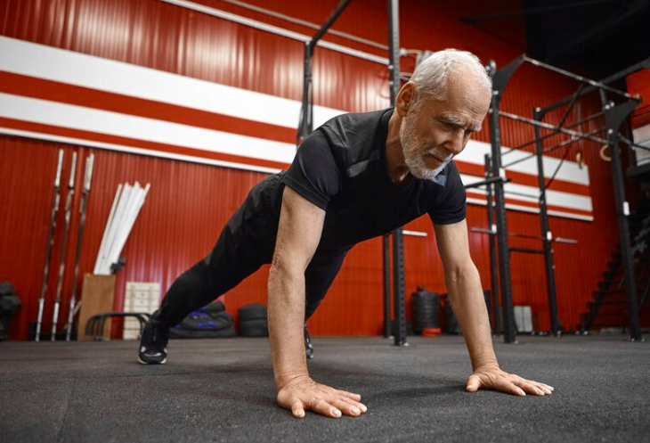 Ældre man dyrker motion i fitness lokale Credit:https://www.freepik.com/free-photo/healthcare-age-retirement-rehabilitation-concept-muscular-fit-seventy-year-old-unshaven-man-sportswear-doing-plank-gym-senior-male-planking-during-morning-workout-fitness-center_10897428.htm#page=2&query=elderly%20men%20gym&position=21&from_view=search&track=ais&uuid=65d359ad-5c75-4023-ac7e-ffa0f3d7409b